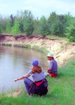 Members of Grand Traverse Hiking Club take a break at the Manistee River while following the North Country Trail.